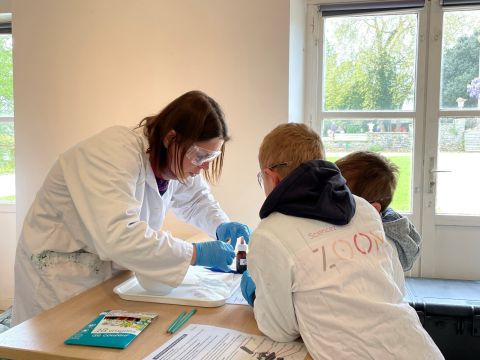 Une animatrice du ZOOM et deux enfants en train de participer à un atelier de sciences